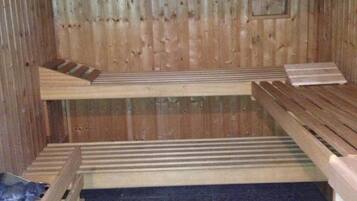 A sauna with wooden benches and a tiled floor.