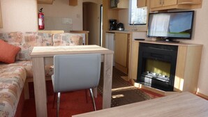 A compact RV interior with a kitchenette, a dining area, and a seating space. - Gasthof Turm (Schoenwald)