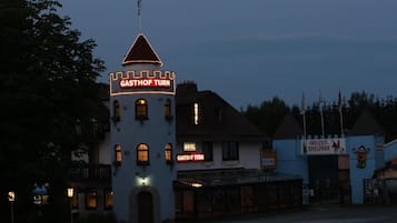 A building with a tower labeled "GASTHOF TURM" and a sign for a hotel.