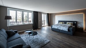 Ein modernes Schlafzimmer mit einem großen Bett, einer Couch und einem kleinen Tisch.