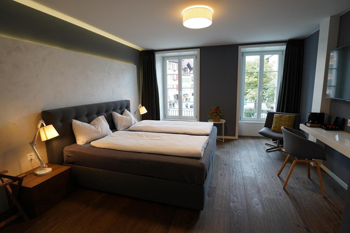 Een hotelkamer met een groot bed, een bureau en een stoel.