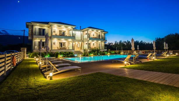 A two-story house with a swimming pool, deck chairs, and umbrellas. - Zante Suites (Zakynthos)