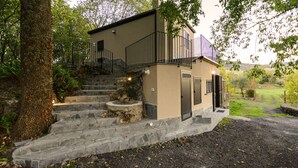 Una casa de dos pisos con una escalera de piedra que conduce a un balcón.