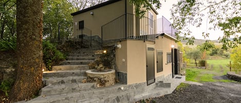 Una casa de dos pisos con una escalera de piedra que conduce a un balcón.