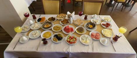 A breakfast buffet with various dishes and drinks on a table.