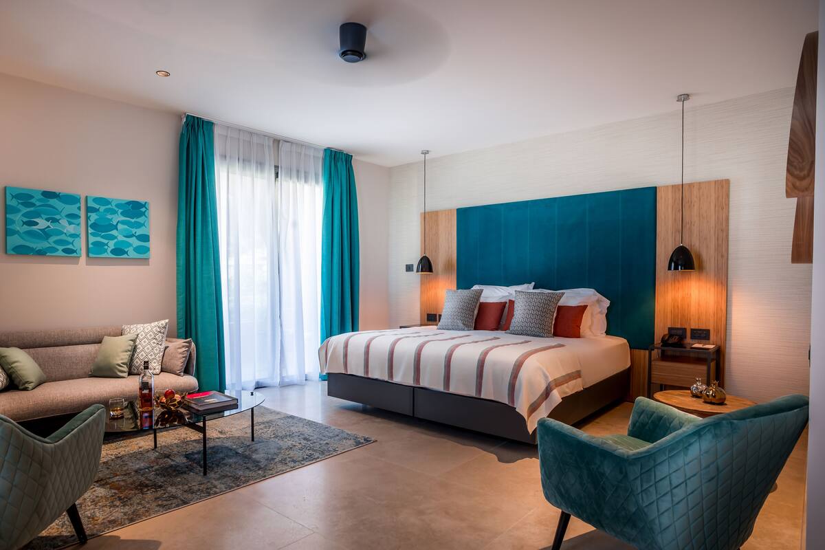 Ein modernes Hotelzimmer mit einem großen Bett, einer Couch, einem Couchtisch und einem Sessel.