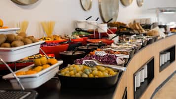 A buffet with various food items and utensils.