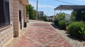 Un sendero pavimentado con un diseño geométrico, bordeado por edificios y vegetación.