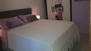 A bedroom with a bed, pillows, a nightstand, and a wardrobe. - Apartment Sabina & Grapes (Malinska-Dubasnica)