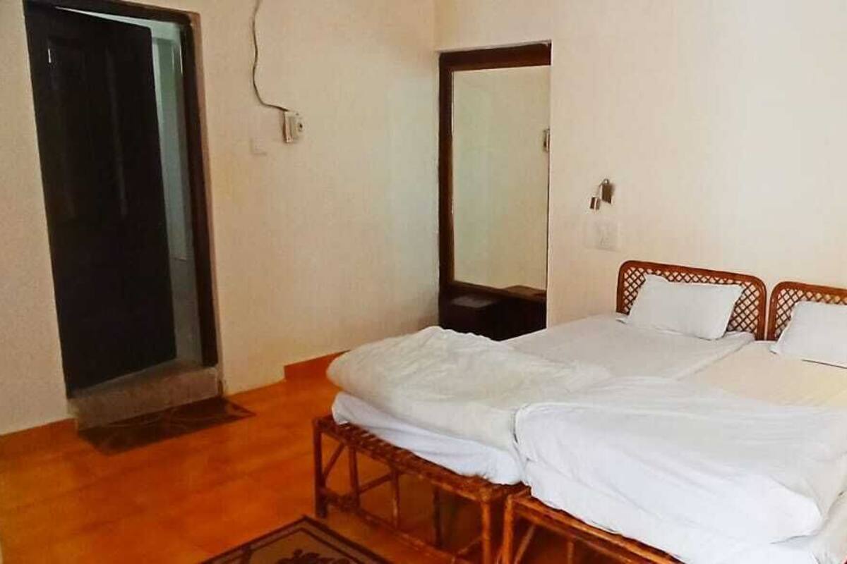 A room with a double bed, wooden headboard, and a small wooden table.