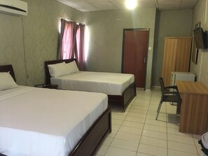 Une chambre d’hôtel avec deux lits simples, un bureau, une chaise, une armoire et un téléviseur fixé au mur.