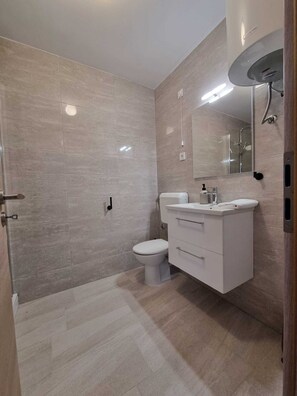 A modern bathroom with a toilet, sink, and shower. - Apartment Yellow (Malinska-Dubasnica)