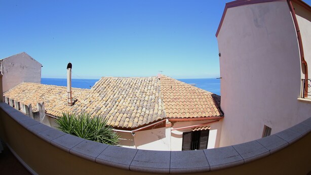 A view of a building with a tiled roof and a balcony overlooking a body of water. - RENOVATED THREE-ROOM APARTMENT IN HISTORIC CENTER - IDEAL FOR SMART WORKING (Pizzo)