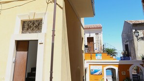 A narrow street with buildings, a visible staircase, and a gate. - RENOVATED THREE-ROOM APARTMENT IN HISTORIC CENTER - IDEAL FOR SMART WORKING (Pizzo)