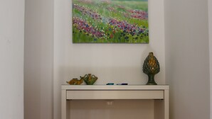 A hallway with a white console table, a painting of a field, and two lanterns. - RENOVATED THREE-ROOM APARTMENT IN HISTORIC CENTER - IDEAL FOR SMART WORKING (Pizzo)