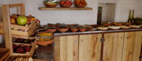 A buffet setup with various food items and a wooden cabinet in the background.