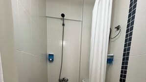 A small, tiled bathroom with a shower, toilet, and sink. - Siren Pansiyon (Foça)