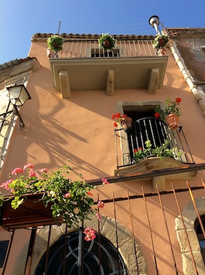 Traditional Mediterranean-style building with a balcony and potted plants.