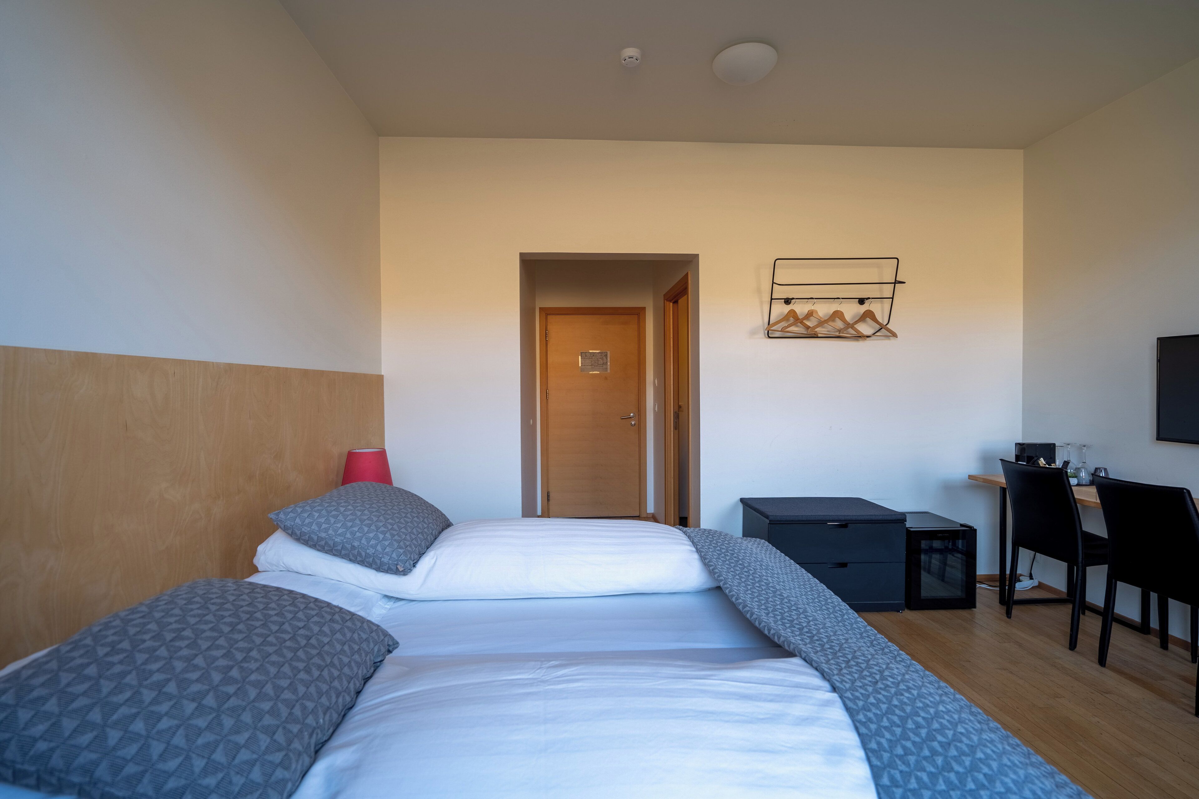 Una habitación de hotel con cama, escritorio, silla y armario.