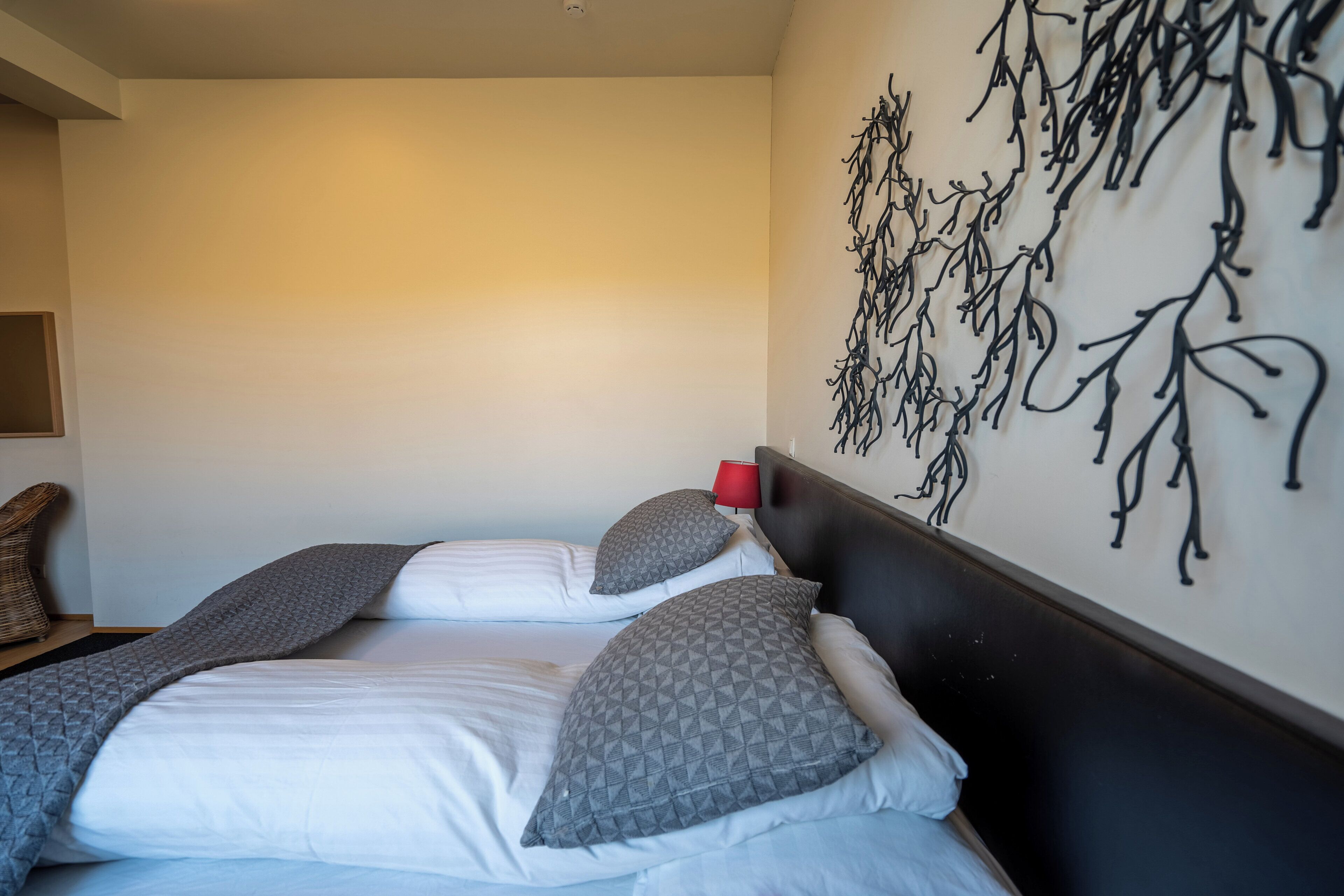 Ein Hotelzimmer mit zwei Betten, einer roten Lampe und einem Wandbild.