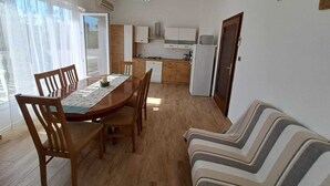 Um espaço compacto com área de refeições, cozinha compacta e sofá.
