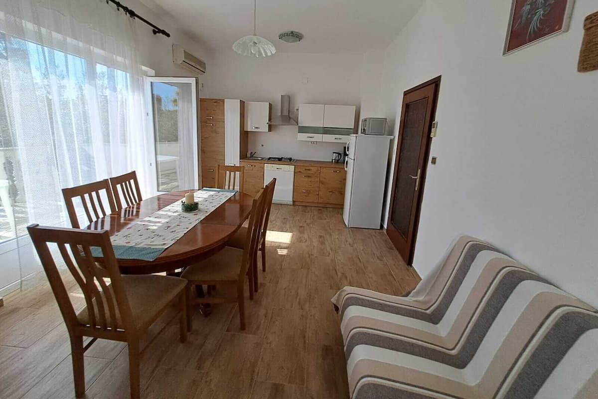A compact living space with a dining area, kitchenette, and a sofa.