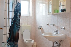 Un baño con inodoro, lavamanos y ventana.