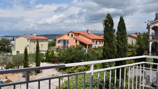 Un quartier résidentiel avec des maisons, un balcon et une vue sur la mer.