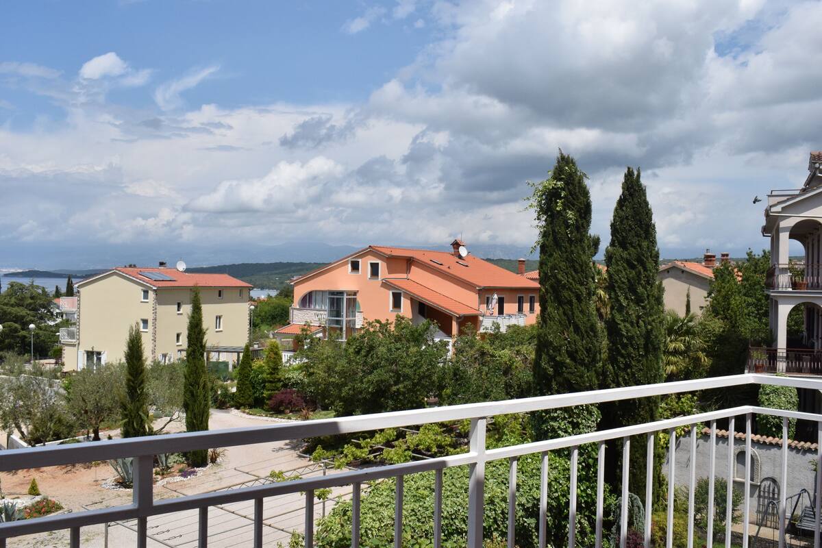A residential area with houses, a balcony, and a view of the sea.