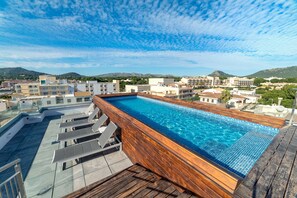 Una piscina al aire libre, tumbonas