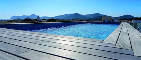 Alberca al aire libre y camastros