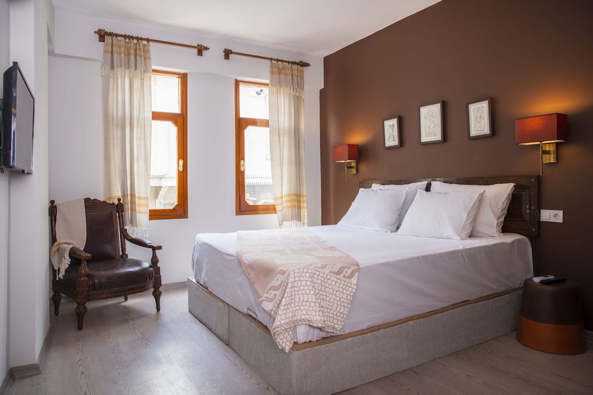 Ein Hotelzimmer mit einem großen Bett, einem Sessel und einem kleinen Tisch.