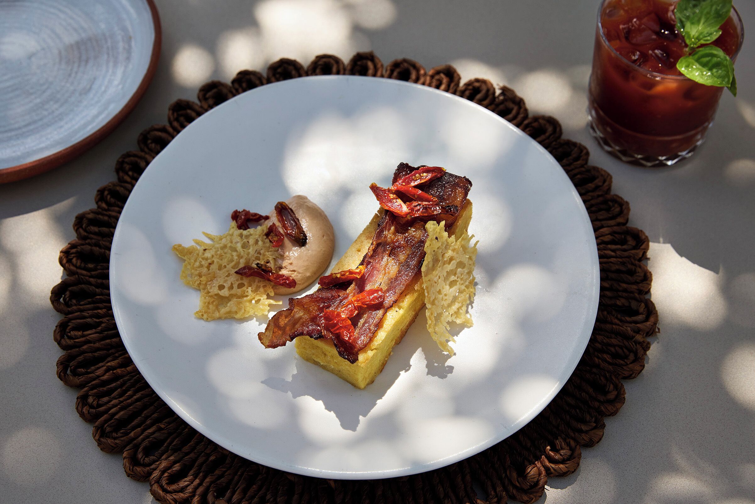 Un plato con comida y una bebida sobre una mesa.