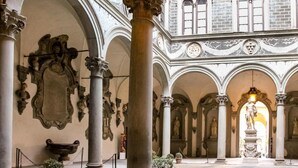 Un patio interior de arquitectura clásica, con columnas, arcos y estatuas.