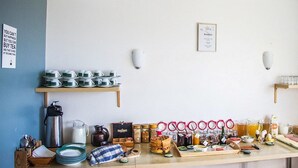 A breakfast bar with tea sets, mugs, and breakfast items. - Vik HI hostel (Vik I Myrdal)