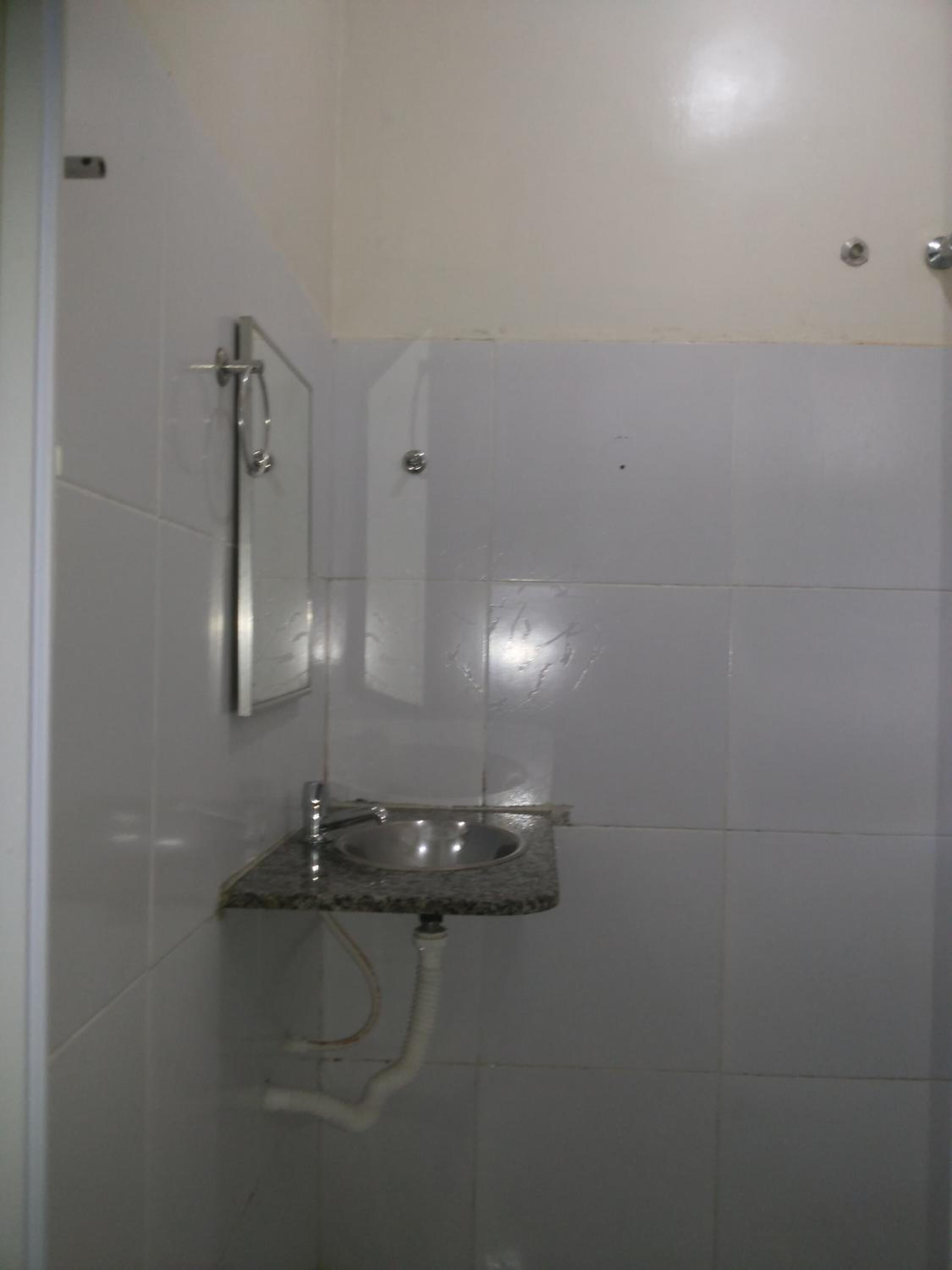 A bathroom with a sink, mirror, and shower.