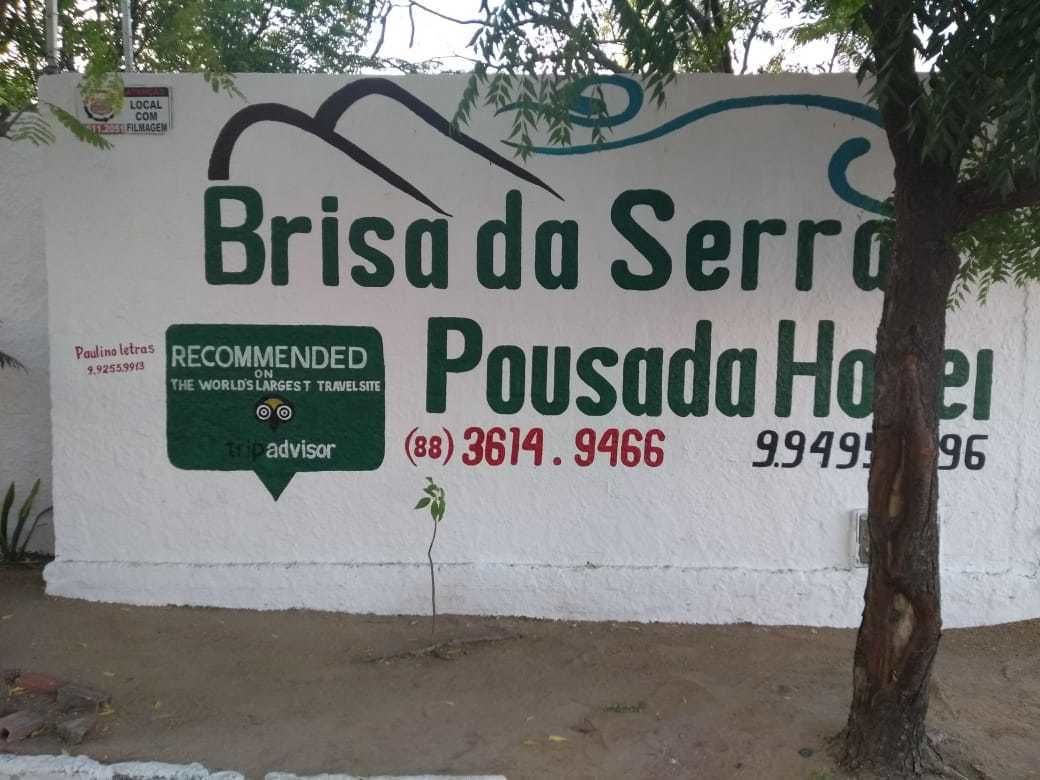 Eine Wand mit dem Schriftzug 'Brisa da Serra Pousada Hotel' und einer Telefonnummer.