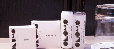 Un ensemble de produits de toilette d’hôtel comprenant un bonnet de douche, du savon et une lotion pour le corps.