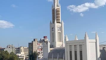 Una iglesia alta con una cruz en la parte superior, rodeada de otros edificios y árboles.