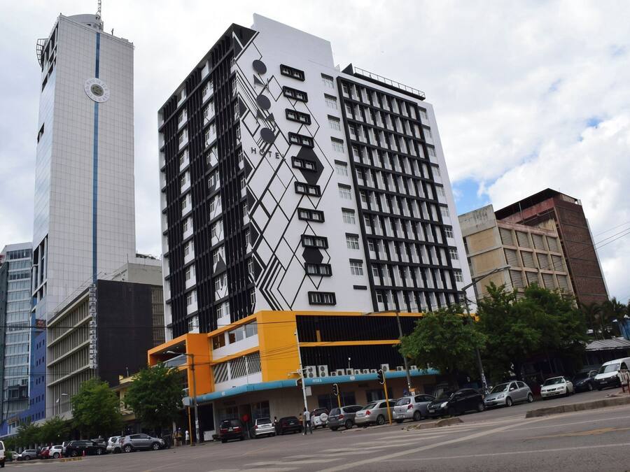 A multi-story hotel with a modern facade, featuring a geometric pattern and a prominent 'HOTEL' sign.