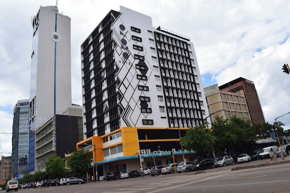 A multi-story hotel with a modern facade, featuring a geometric pattern and a prominent 'HOTEL' sign.