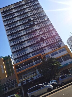 En høj bygning med moderne arkitektur, med flere balkoner og store vinduer.