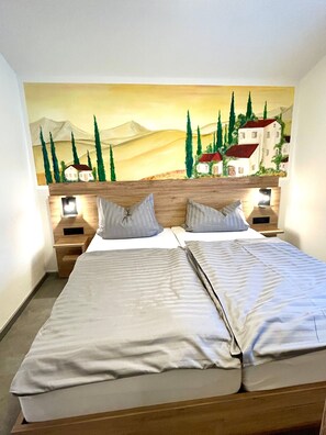 A double bed with a wooden headboard and two bedside tables, each with a lamp.