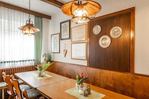 A dining area with wooden furniture, a hanging lamp, and wall-mounted plates. - Category C: Double Room - Inn - Pension - Drei Linden (Pegnitz)