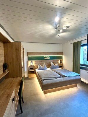 Una camera da letto con un letto, comodini, una scrivania e una finestra con tende.