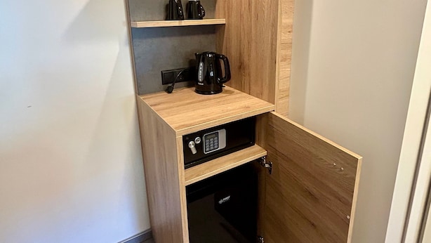 A compact storage unit with shelves, a coffee maker, and a small plant.