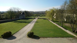A well-maintained lawn with a gravel path leading to a stone structure with a pointed roof. - Manoir de Conjon (Crouay)