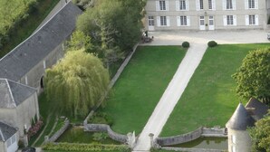 A large, historic building with a symmetrical facade, a central courtyard, and a small tower. - Manoir de Conjon (Crouay)