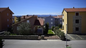 A residential area with houses featuring red-tiled roofs and a clear sky. - Apartment Grace (Malinska-Dubasnica)