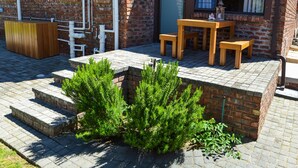 A brick building with a wooden outdoor seating area, a small wooden table and benches, and a sign that reads "The Chilled."